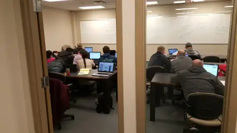 Large lecture hall filled with students listening to a presenter