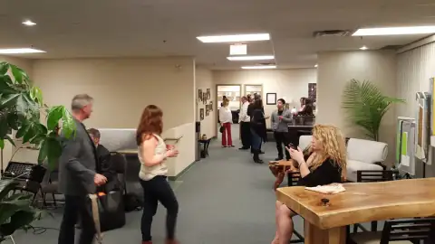 Guests mingling in a hallway during an art opening reception