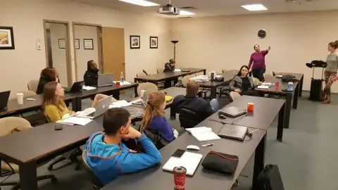Instructor guiding students working on laptops during bootcamp