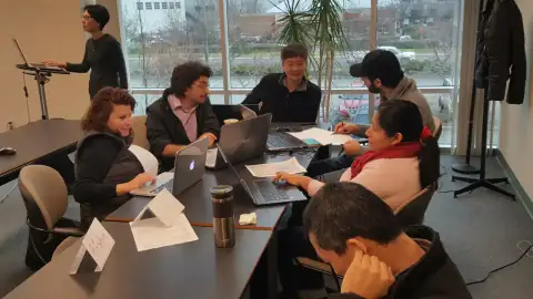 Bootcamp instructor presenting a workflow diagram on the whiteboard