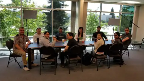 Group of participants seated at a table smiling for the camera