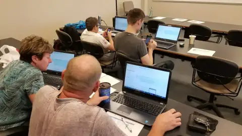 Students seated with laptops during a technical lecture