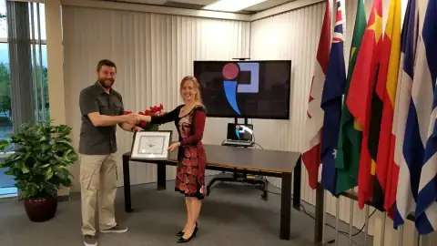 START Canada leader congratulating a graduate with a framed certificate