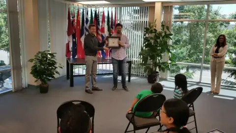 Instructor shaking hands with a graduate while presenting a certificate