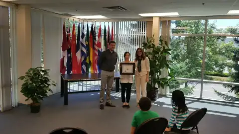 Graduate receiving congratulations while holding a framed certificate