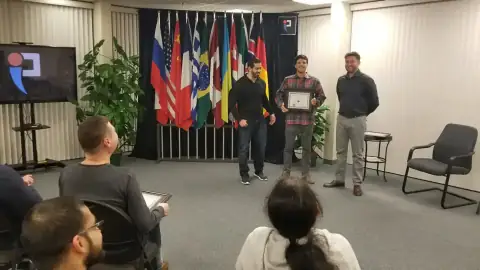 Graduate posing with certificate alongside START Canada mentors