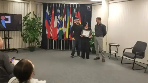 START Canada alumna holding certificate while being congratulated