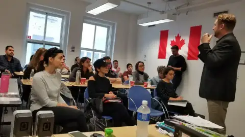 Students seated in a classroom with laptops open during a workshop
